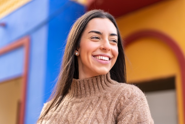 Jovem morena ao ar livre com uma expressão feliz