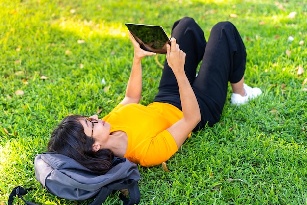 Jovem morena ao ar livre segurando um tablet