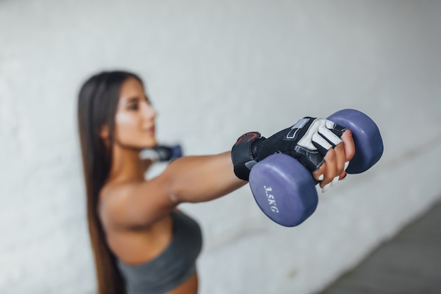 jovem morena bonita tem exercícios no ginásio loft. fechar foto de barra