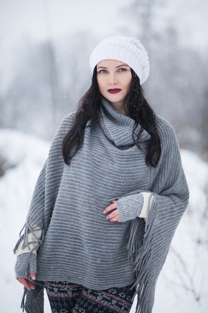 Jovem morena com roupas de inverno posando ao ar livre