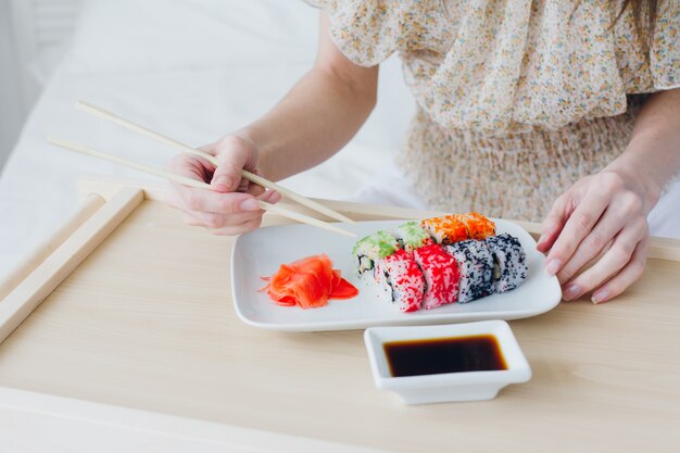 Jovem morena comendo sushi