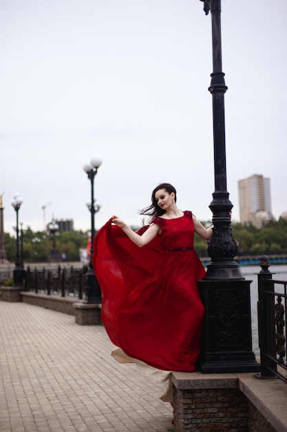 Jovem morena de vestido vermelho com um trem