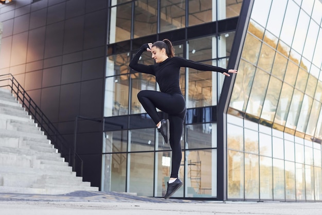 Jovem morena em roupas esportivas tem dia de fitness ao ar livre na cidade