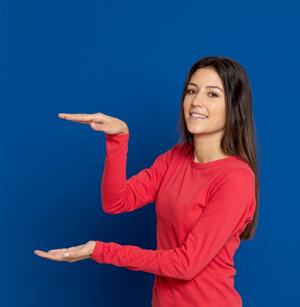 Jovem morena gesticulando sobre parede azul