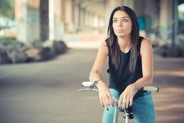 jovem morena linda mulher de cabelo liso, usando a bicicleta