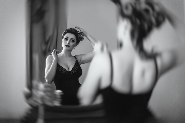 Jovem morena modelo mulher e atriz em frente a um espelho, preto e branco