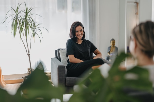 Foto jovem morena ri enquanto conversa com seu psicólogo