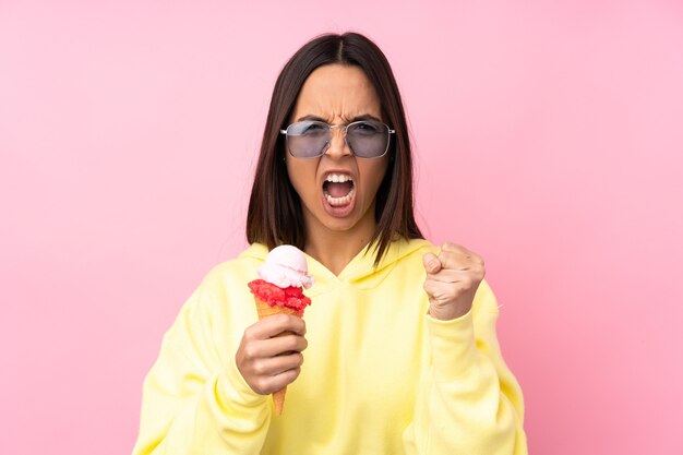 Jovem morena segurando um sorvete de corneta em uma rosa isolada frustrada por uma situação ruim