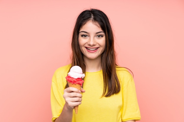 Jovem morena segurando um sorvete de corneta rosa com surpresa e expressão facial chocada