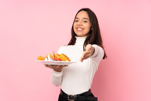 Jovem morena segurando waffles isolados