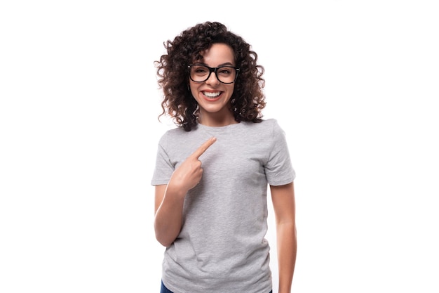 Jovem morena sorridente mulher encaracolada vestida com uma camiseta básica cinza com impressão de loy espaço em têxtil