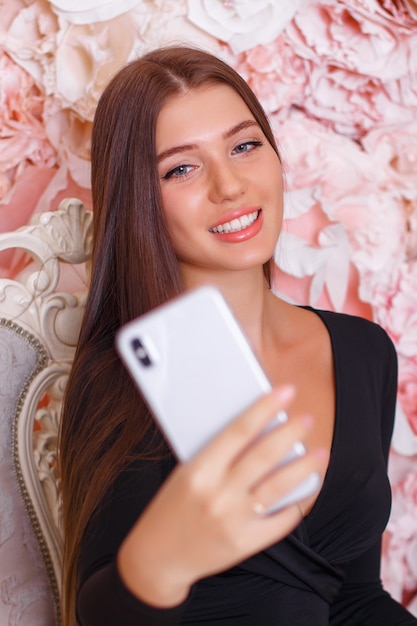 Jovem morena tirando uma selfie no telefone