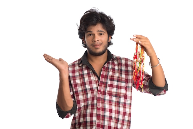 Jovem, mostrando o rakhi na mão e dando expressão em uma ocasião do festival Raksha Bandhan.