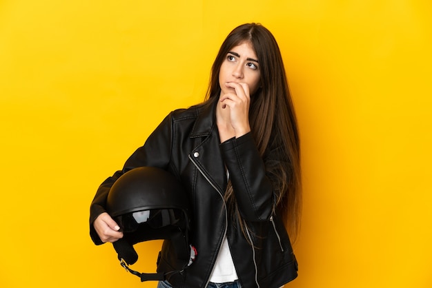 Jovem motociclista segurando um capacete de motociclista