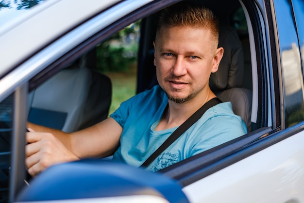 Jovem motorista atraente no carro branco