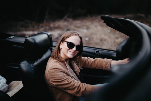 jovem motorista em carro conversível no verão