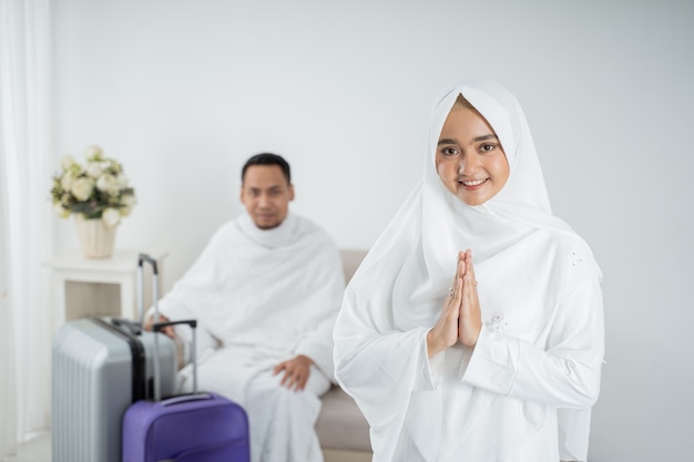 Jovem muçulmana em pé na frente do marido antes de umrah