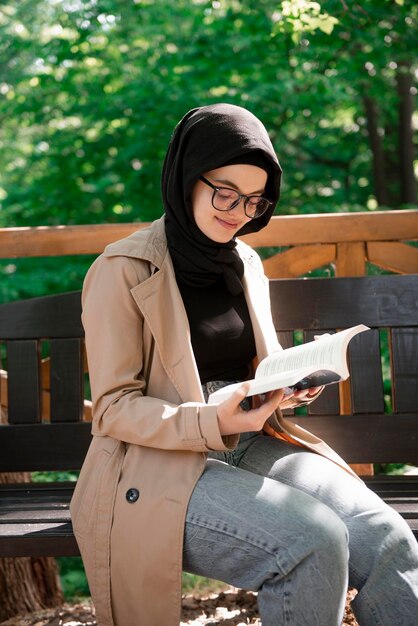 Jovem muçulmana lendo poesia em silêncio em um lindo dia de primavera