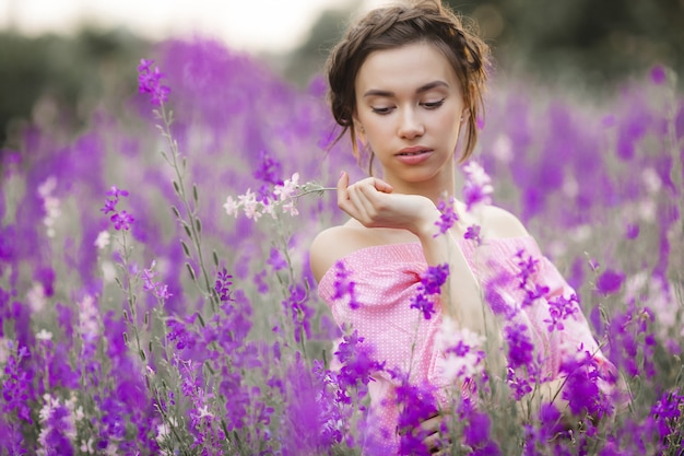 Jovem muito bonita com flores. Feche o retrato da mulher atraente