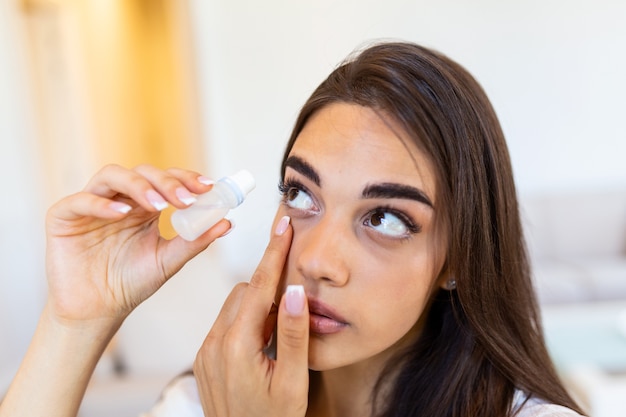 Foto jovem mulher a colocar lubrificante para os olhos