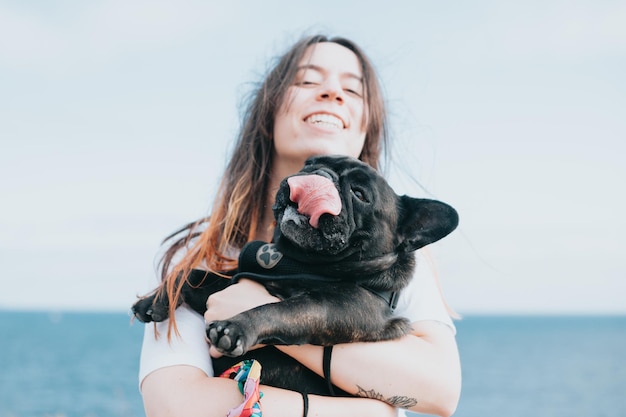 Jovem mulher abraçando cachorro fofo na natureza com espaço de cópia durante um feliz dia de passeio buldogue francês cachorro de raça pura Novo membro da família