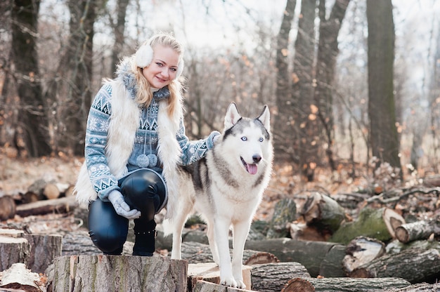 Jovem mulher abraçando seu cão husky