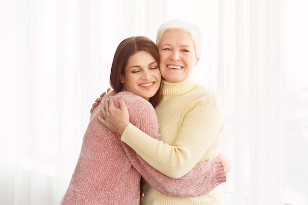 Jovem mulher abraçando sua mãe com amor