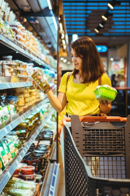 Jovem mulher adulta bonita faz compras na mercearia