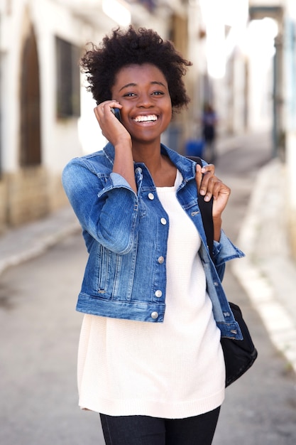 Jovem mulher africana andando e falando no celular