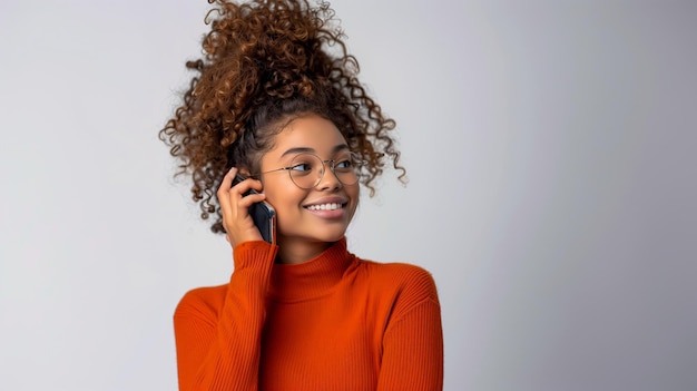 Jovem mulher afro-americana a falar no telemóvel sobre um fundo cinzento