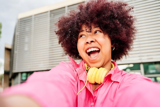 Jovem mulher afro-americana com cabelo encaracolado, tirando uma selfie