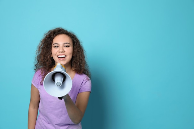 Foto jovem mulher afro-americana com megafone na cor de fundo espaço para texto