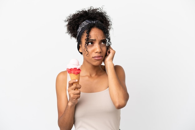 Jovem mulher afro-americana com um sorvete de corneta isolado no fundo branco frustrada e cobrindo as orelhas