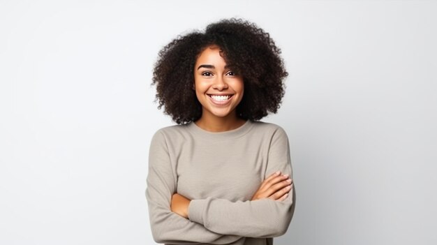 Jovem mulher afro-americana cruza os braços isolado fundo e sorrindo