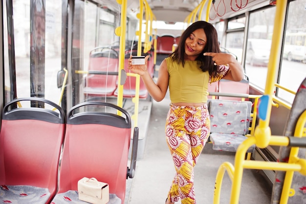 Jovem mulher afro-americana elegante andando de ônibus