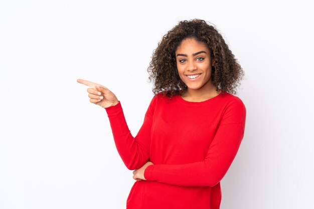 Jovem mulher afro-americana isolada em apontar o dedo para o lado