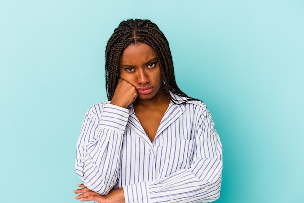 Foto jovem mulher afro-americana isolada em um fundo azul que se sente triste e pensativa, olhando para o espaço da cópia.