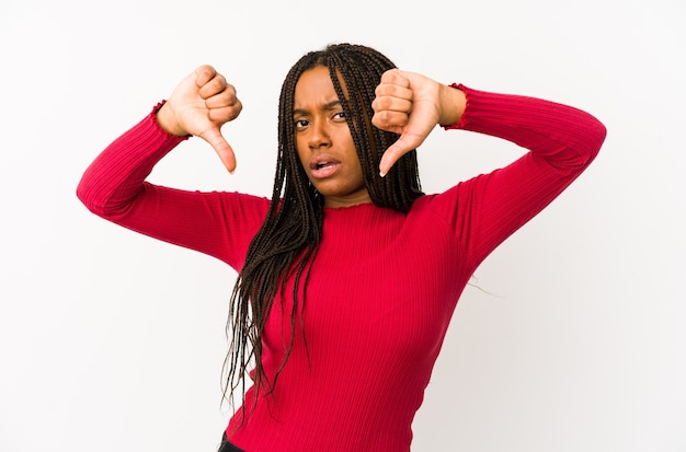 Jovem mulher afro-americana isolada mostrando o polegar para baixo e expressando antipatia.