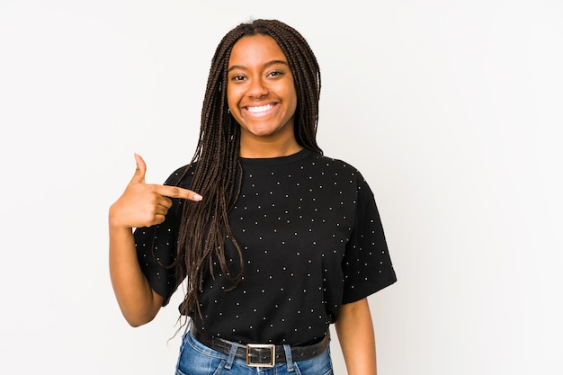 Foto jovem mulher afro-americana isolada na superfície branca pessoa apontando com a mão para um espaço de cópia de camisa, orgulhosa e confiante