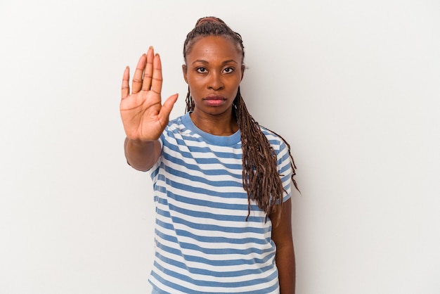 Jovem mulher afro-americana isolada no fundo branco, de pé com a mão estendida, mostrando o sinal de stop, impedindo você.