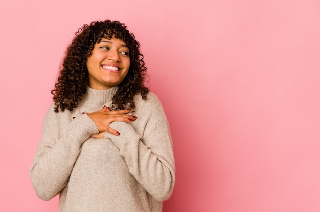 Jovem mulher afro-americana isolada rindo mantendo as mãos no coração, o conceito de felicidade.