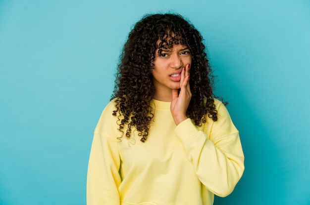 Jovem mulher afro-americana isolada tendo uma forte dor nos dentes, dor molar.