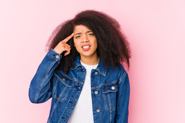 Jovem mulher afro-americana, mostrando um gesto de decepção com o dedo indicador.