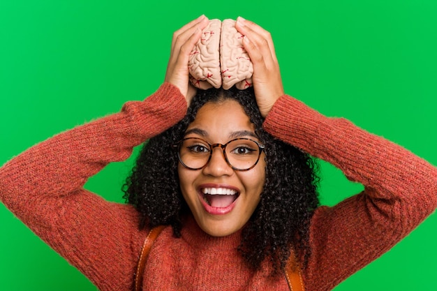 Jovem mulher afro-americana segurando um modelo de cérebro isolado