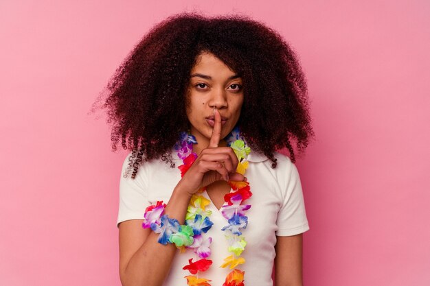 Jovem mulher afro-americana usando uma roupa havaiana, mantendo um segredo ou pedindo silêncio.