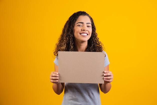 Jovem mulher afro com cartão com espaço livre para texto. Conceito de promoção. Oferta. Sexta-feira preta