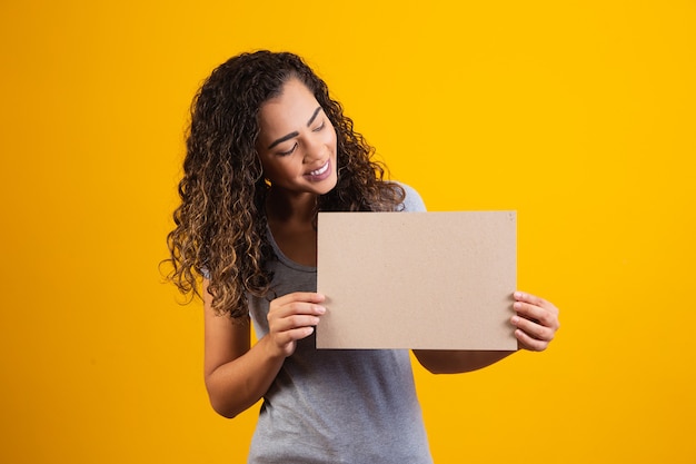 Jovem mulher afro com cartão com espaço livre para texto. Conceito de promoção. Oferta. Sexta-feira preta