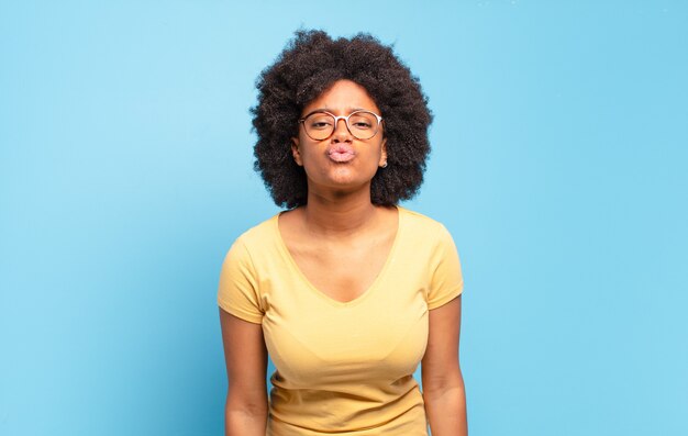 jovem mulher afro contra parede isolada