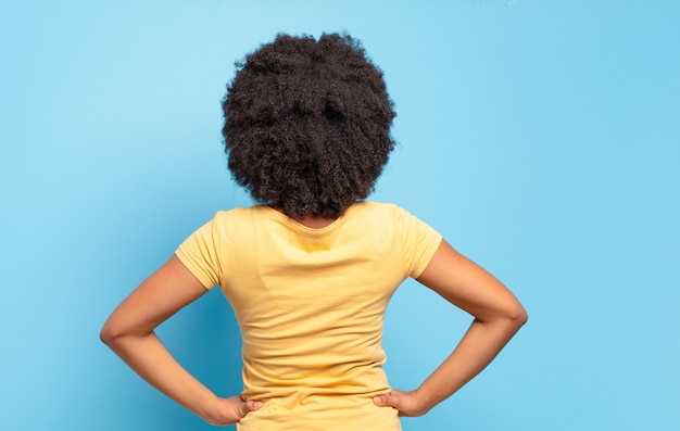 jovem mulher afro contra parede isolada