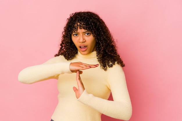 Jovem mulher afro isolada mostrando um gesto de tempo limite